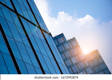 Modern architecture with sun ray. Glass facade on a bright sunny day with sunbeams in the blue sky.