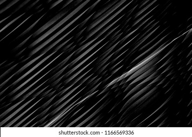 Modern architecture viewed through blinds / louvers. Wavy dark gray / black texture. Reworked close-up photo of wall surface in darkness. Grunge abstract black and white interior background.