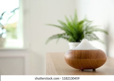 Modern aroma lamp on table against blurred background with space for text - Shutterstock ID 1182130459
