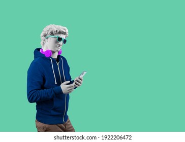 Modern art collage. Concept portrait of a man  holding mobile smartphone using app texting sms message. Gypsum head of of David.