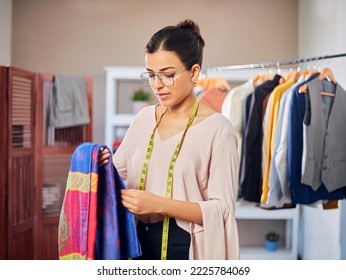 Modern attractive Young Indian Asian woman or female professional fashion designer is holding a colorful piece of cloth in a store or garments boutique workshop. Concept of self-employment. - Powered by Shutterstock