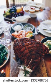 Modern Australian Christmas Dinner Table With Glazed Ham, Prawns, Potatoes And Dill, Asian Greens, Christmas Pudding, Minced Fruit Pies By Candlelight