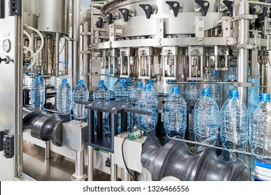 Modern automated mineral water bottling line at the plant. Industrial background.
