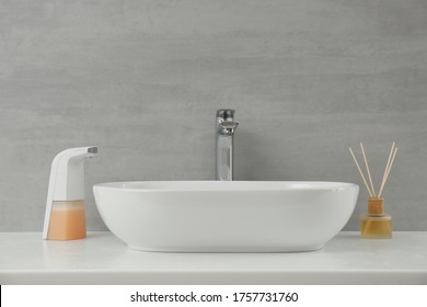 Modern Automatic Soap Dispenser Near Sink In Bathroom