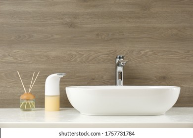 Modern Automatic Soap Dispenser Near Sink In Bathroom