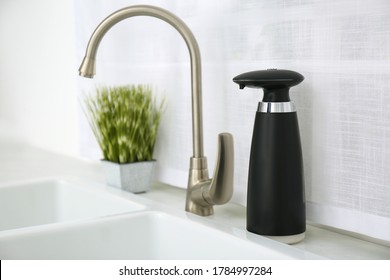 Modern Automatic Soap Dispenser Near Sink In Kitchen