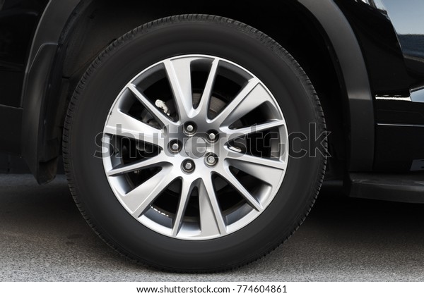 Modern automotive wheel on light alloy disc, close\
up photo