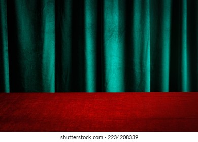Modern background with empty red cloth table and green draped velvet curtains. Template for advertising, presentation, cosmetic products. Mockup, texture.