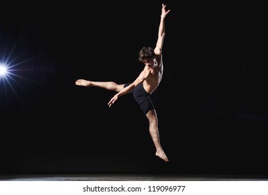 Modern Ballet Style Male Dancer Performs On High Lighted Stage .
