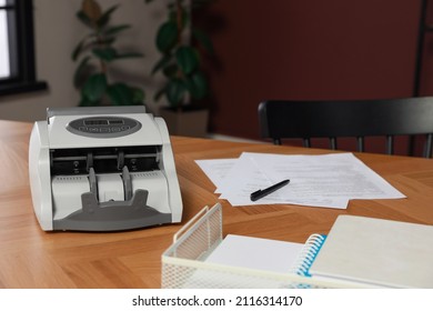 Modern Banknote Counter On Wooden Table Indoors