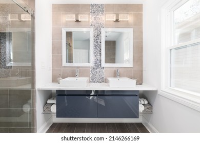 A Modern Bathroom With A Blue Cabinet, Tile And Stone Backsplash, And Marble On The Floor And Shower Walls.