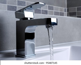 Modern bathroom chrome faucet with running water - Shutterstock ID 95487145