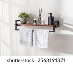 Modern bathroom floating shelf with a black metal frame, decorative elements like a potted plant, reed diffuser, soap dispenser, and white towels, highlighting minimalist and clean interior design.