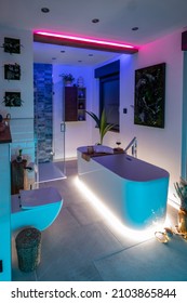 Modern bathroom with freestanding bathtub, modern taps and blue LED ambient lighting - Shutterstock ID 2103865844