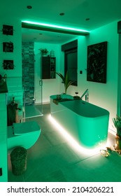 Modern bathroom with freestanding bathtub, modern taps and green LED ambient lighting - Shutterstock ID 2104206221