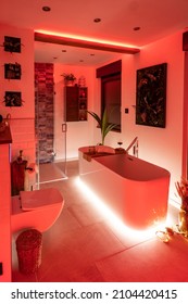 Modern bathroom with freestanding bathtub, modern taps and red LED ambient lighting - Shutterstock ID 2104420415