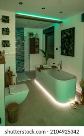 Modern bathroom with freestanding bathtub, modern taps and green LED ambient lighting - Shutterstock ID 2104925342