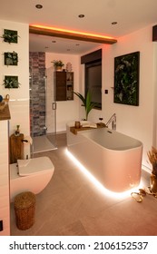 Modern bathroom with freestanding bathtub, modern taps and red LED ambient lighting - Shutterstock ID 2106152537