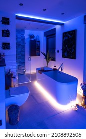 Modern bathroom with freestanding bathtub, modern taps and blue LED ambient lighting - Shutterstock ID 2108892506