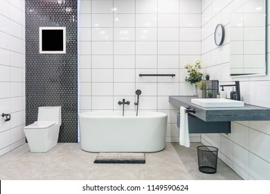 Modern bathroom interior with minimalistic shower and lighting, white toilet, sink and bathtub