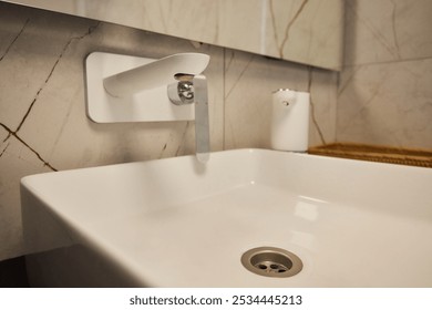 A modern bathroom sink with a sleek faucet and soap dispenser, enhancing the spaces aesthetic - Powered by Shutterstock