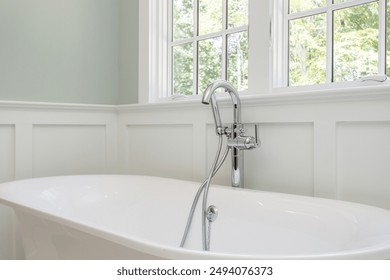 Modern Bathroom With A White Freestanding Bathtub Under Large Bright Windows - Powered by Shutterstock