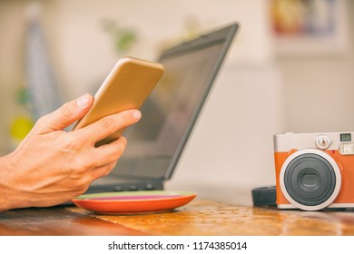 Modern bearded man using cellphone and drinking coffee with laptop.