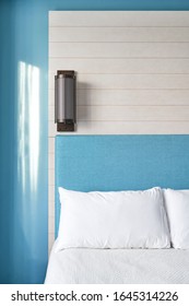 A Modern Bedroom With A Blue Wall And Light Fixture