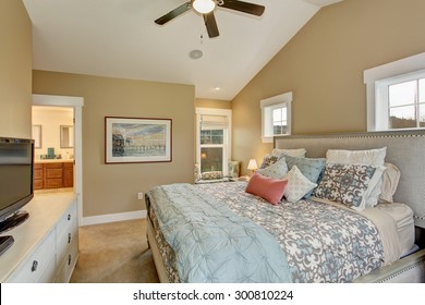 Modern Bedroom With Decorative Bedding And A Ceiling Fan.