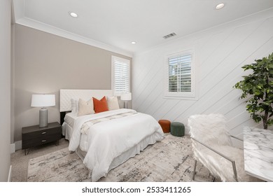 Modern bedroom interior with white and beige decor, featuring a bed, nightstands, a desk, and a large plant, well-lit by natural light. - Powered by Shutterstock