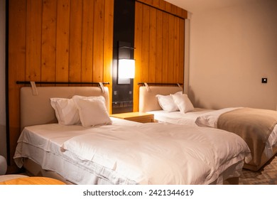 Modern bedroom in Nathiagali, Pakistan, offering stunning mountain views. Ideal hotel accommodation with contemporary design as well as furniture in a five-star hotel room showing two beds  - Powered by Shutterstock