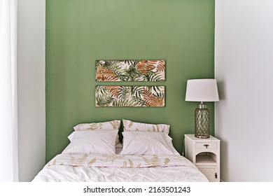 Modern bedroom in olive and beige tones in floral tropical style, bed bedside table and table lamp - Shutterstock ID 2163501243
