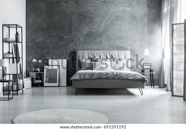 Modern bedroom with simple furniture, gray\
bedding and soft\
headboard