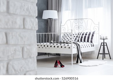 Modern Bedroom With White Brick Wall And Metal Frame Bed