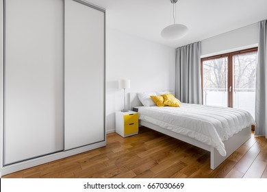 Modern bedroom with white wardrobe and double bed