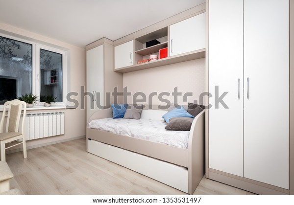 Modern beige bedroom\
with wardrobe and sofa