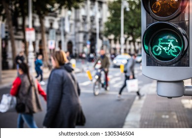 Modern bicycle traffic light glowing green with cyclist riding on street behind, Dublin