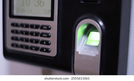 Modern biometric fingerprint scanner with glowing green sensor for secure access, used in advanced security systems, enhancing data protection and workplace safety. - Powered by Shutterstock