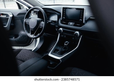 Modern black car interior, leather steering wheel, climate control, navigation, air ducts, deflectors on the car panel. Details interior.  - Powered by Shutterstock