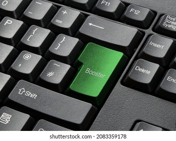 A Modern Black Computer Keyboard With Return Key Coloured Green With Text Booster