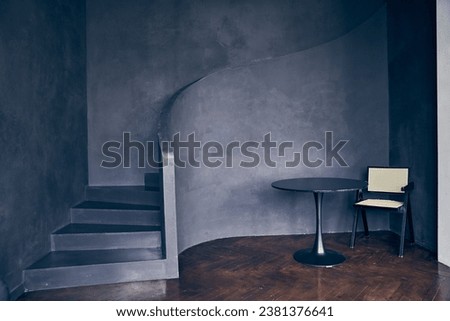 A modern black curved staircase indoors, a staircase made of black stone, a symbol of modern life. With space to copy. High quality photo