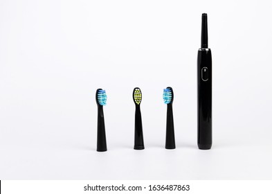 Modern Black Electric Toothbrush With Three Nozzles For The Whole Family On A White Background Are Standing Upright Caries