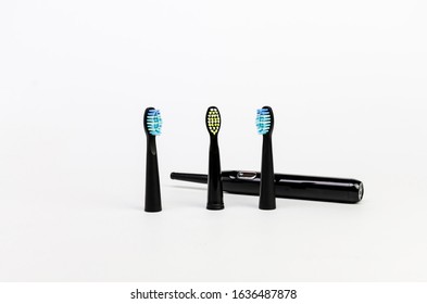 Modern Black Electric Toothbrush With Three Nozzles For The Whole Family On A White Background Are Standing Upright Caries