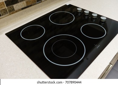 Modern black induction stove, cooker, hob or built in cooktop with ceramic top in white kitchen interior