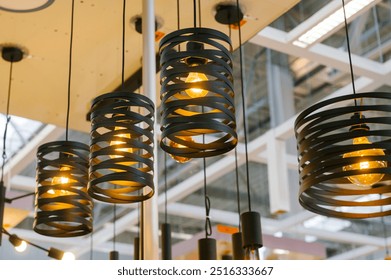 Modern black pendant lights illuminating a showroom with industrial design - Powered by Shutterstock