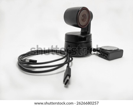 A modern black webcam with a built-in microphone USB cable and a magnetic clip on a white background suitable for online meetings and streaming
