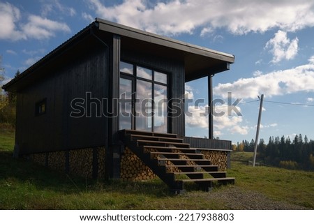 Modern black wooden house with big windows on Carpathian mountains in Ukraine