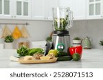 Modern blender with ingredients for smoothie on white marble table in kitchen