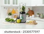 Modern blender with ingredients for smoothie on white marble table in kitchen