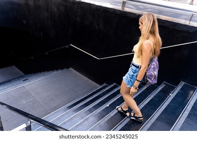 Modern blonde girl entering the subway entrance - Powered by Shutterstock